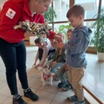 Frau vom Österreichischen Roten Kreuz und Schulkind mit Therapiebegleithund